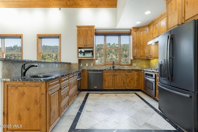 416 Eby Creek Rd, Eagle, CO 81631 - kitchen featuring stainless steel appliances, brown cabinetry, inlaid floor details, a peninsula, and dark stone counters