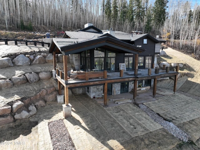 181 Black Bear Trl, Edwards, CO 81632 - rear view of house featuring a patio area, stone siding, and a wooden deck