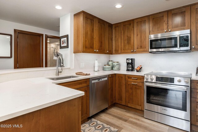 120 Offerson Rd Unit 3460, Beaver Creek, CO 81620 - kitchen featuring stainless steel appliances, a sink, light countertops, brown cabinets, and recessed lighting