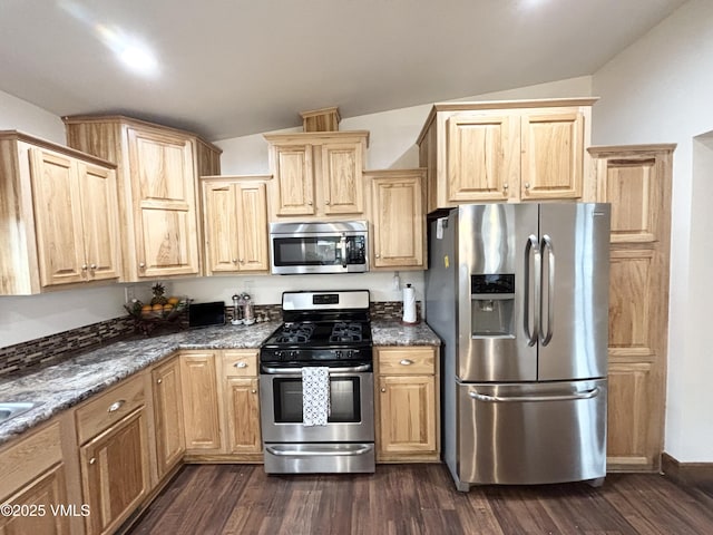 66 Bluegill Loop, Gypsum, CO 81637 - kitchen with stainless steel appliances, lofted ceiling, light brown cabinets, dark stone countertops, and dark wood-style flooring
