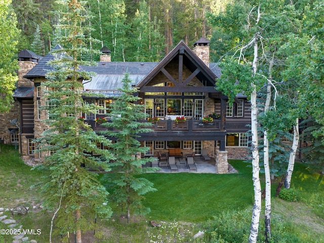 140 Elk Woods Rd, Edwards, CO 81632 - back of house featuring a chimney, stone siding, a patio area, and a yard