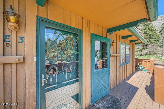 entrance to property featuring a wooden deck and board and batten siding