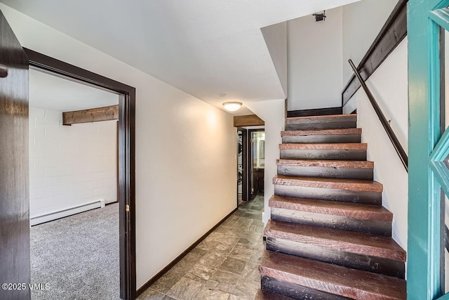 stairs featuring stone finish floor, a baseboard radiator, and baseboards