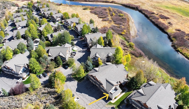 drone / aerial view featuring a residential view and a water view