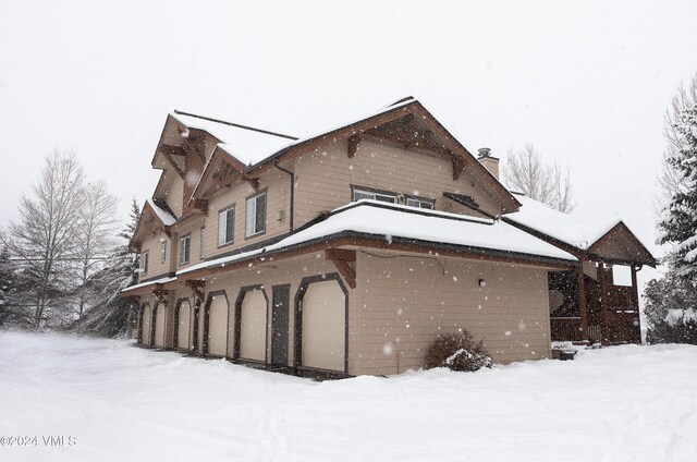 view of snowy exterior with a chimney