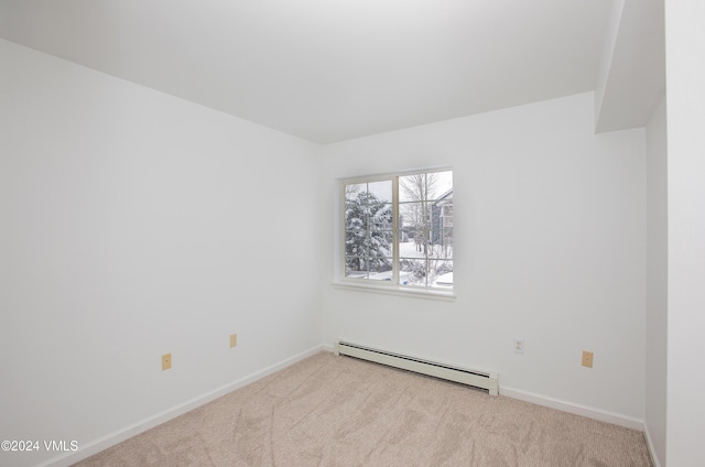 unfurnished room with baseboard heating, baseboards, and carpet floors