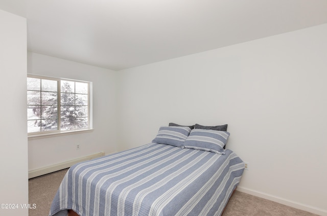 bedroom with a baseboard heating unit, baseboards, and carpet