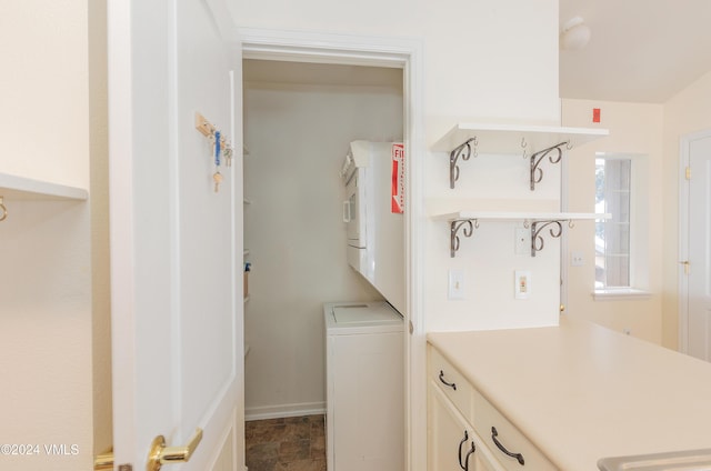 washroom with laundry area, stacked washer / dryer, and baseboards