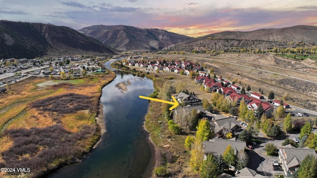 aerial view at dusk featuring a residential view and a water and mountain view