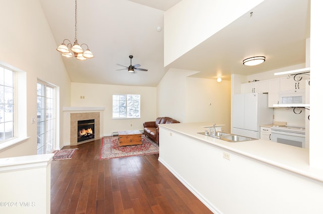 unfurnished living room with plenty of natural light, dark wood-style flooring, a fireplace, and a sink