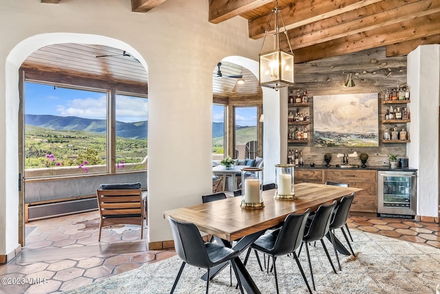 767 Charolais Cir, Edwards, CO 81632 - dining room with beverage cooler, arched walkways, wet bar, a wooden ceiling with exposed beams, and a mountain view