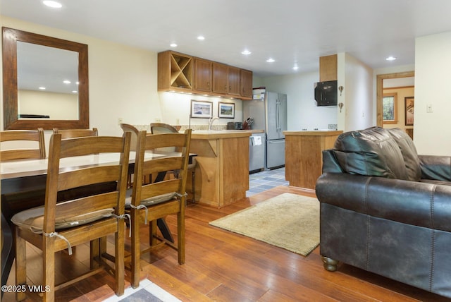2821 Basingdale Blvd Unit 4, Vail, CO 81657 - kitchen with open floor plan, stainless steel appliances, a peninsula, light wood-style flooring, and light countertops
