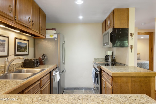 2821 Basingdale Blvd Unit 4, Vail, CO 81657 - kitchen featuring a sink, appliances with stainless steel finishes, brown cabinetry, and recessed lighting