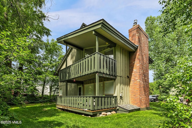 929 Red Sandstone Rd Unit 15D, Vail, CO 81657 - view of front of house featuring a chimney, a front lawn, a deck, and board and batten siding