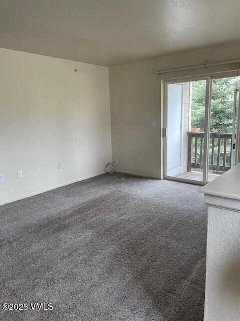 carpeted spare room with baseboards