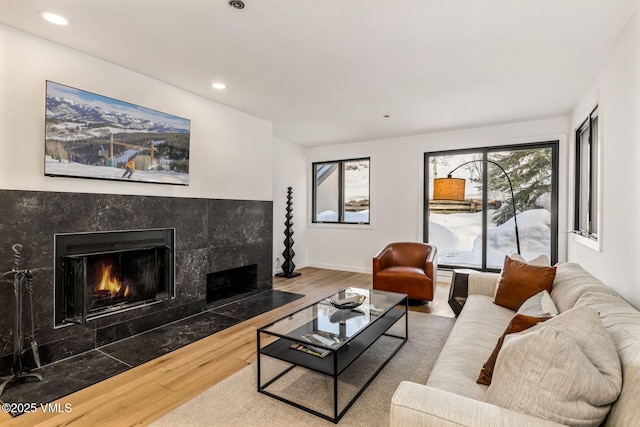 living area featuring recessed lighting, a fireplace, baseboards, and wood finished floors