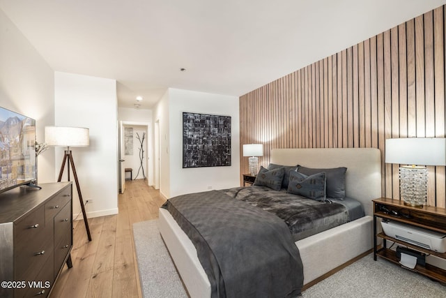 bedroom with light wood-type flooring and baseboards