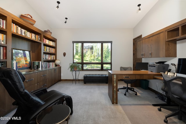 office featuring baseboards, high vaulted ceiling, and light colored carpet