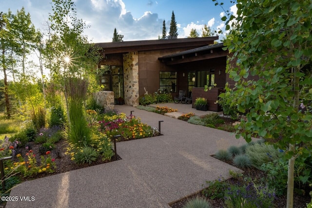 exterior space featuring stone siding and a patio area