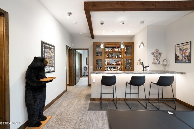 bar featuring baseboards, indoor wet bar, beam ceiling, and decorative light fixtures