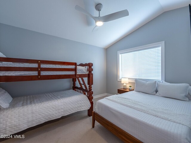 carpeted bedroom featuring ceiling fan and vaulted ceiling