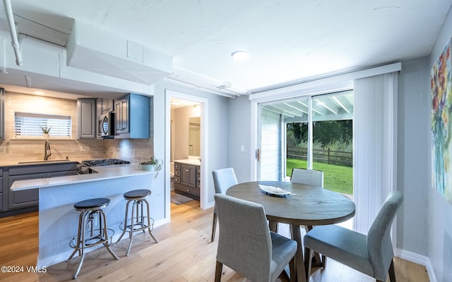 dining room featuring sink and light hardwood / wood-style flooring