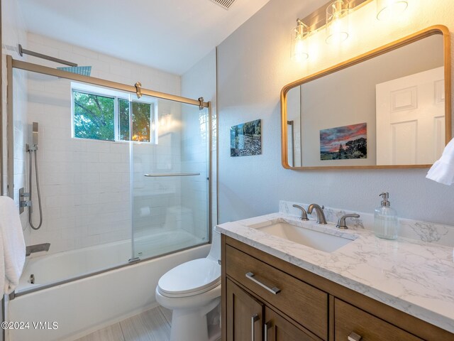 full bathroom with vanity, toilet, and combined bath / shower with glass door