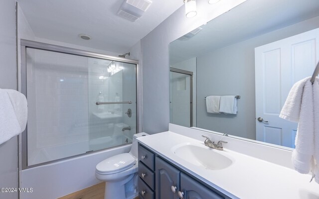 full bathroom with vanity, toilet, and combined bath / shower with glass door