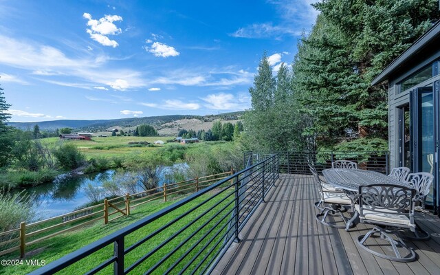 balcony featuring a water and mountain view and a rural view