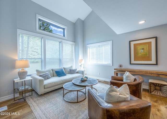 living room with high vaulted ceiling and light wood-type flooring