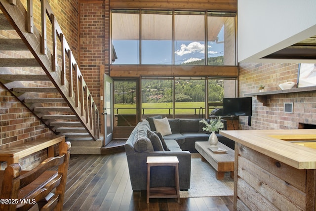 54 Columbine Cir Unit 14, Eagle-Vail, CO 81620 - living area with wood-type flooring, a towering ceiling, brick wall, and stairs