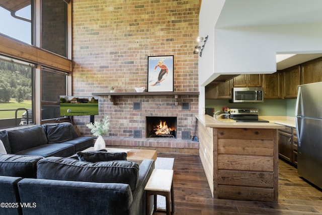 54 Columbine Cir Unit 14, Eagle-Vail, CO 81620 - living room with a fireplace, dark wood-style flooring, brick wall, and a high ceiling
