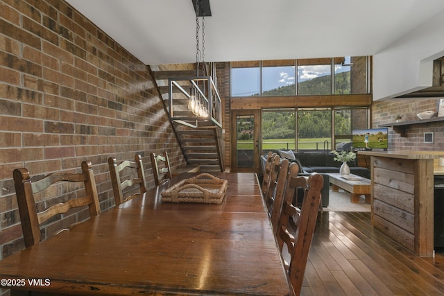 54 Columbine Cir Unit 14, Eagle-Vail, CO 81620 - dining area featuring brick wall, wood-type flooring, and stairs