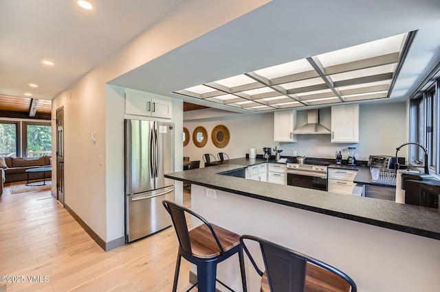 1750 S Frontage Rd W Unit E-3, Vail, CO 81657 - kitchen with stainless steel appliances, wall chimney range hood, a peninsula, dark countertops, and recessed lighting