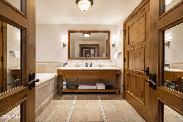 bathroom with vanity and tiled tub