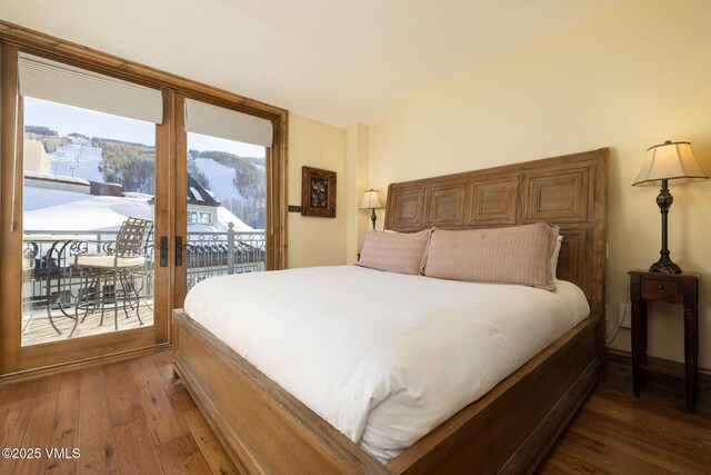 bedroom featuring a mountain view, dark wood-type flooring, access to exterior, and french doors