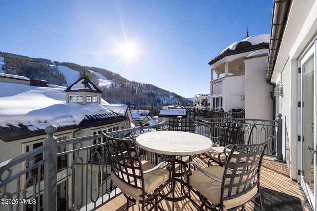 snow covered back of property with a mountain view