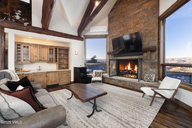 living room featuring a wall mounted air conditioner, beamed ceiling, a fireplace, indoor wet bar, and dark wood-style flooring