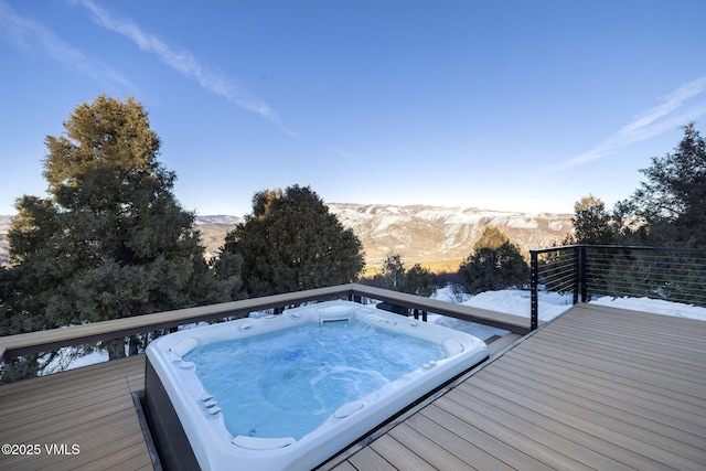 deck featuring a mountain view and hot tub deck surround