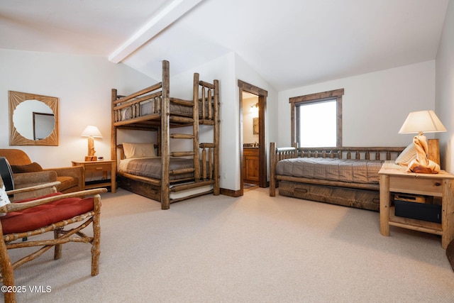 bedroom featuring ensuite bath, carpet flooring, and vaulted ceiling with beams