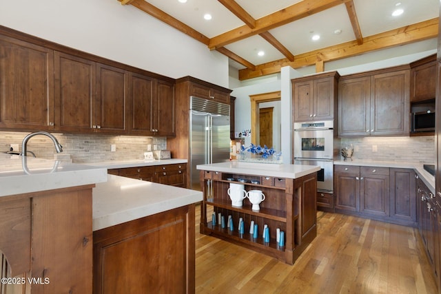 124 Grey Hawk Ln, Edwards, CO 81632 - kitchen featuring stainless steel appliances, light wood finished floors, beam ceiling, open shelves, and backsplash