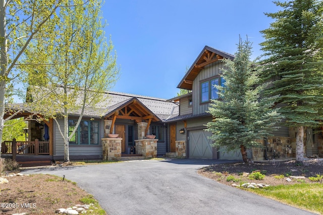 124 Grey Hawk Ln, Edwards, CO 81632 - view of front of house with stone siding, driveway, an attached garage, and board and batten siding