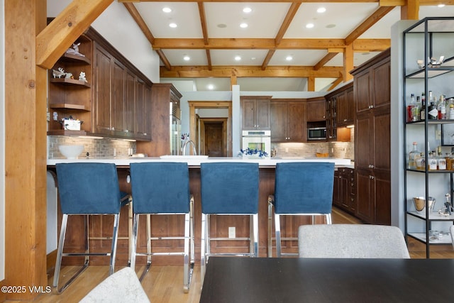 124 Grey Hawk Ln, Edwards, CO 81632 - kitchen with oven, stainless steel microwave, open shelves, light countertops, and decorative backsplash