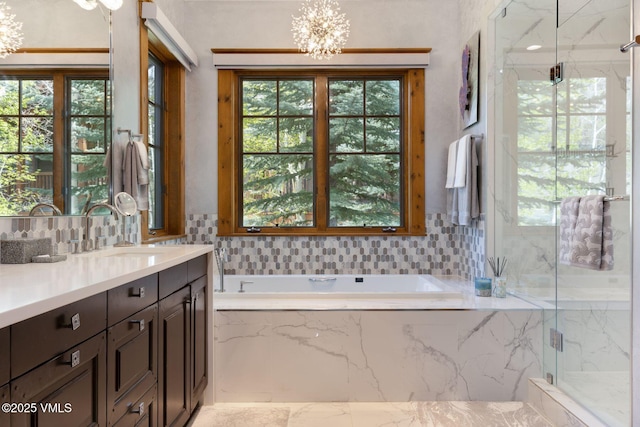 124 Grey Hawk Ln, Edwards, CO 81632 - bathroom featuring vanity, a chandelier, a marble finish shower, a garden tub, and tasteful backsplash