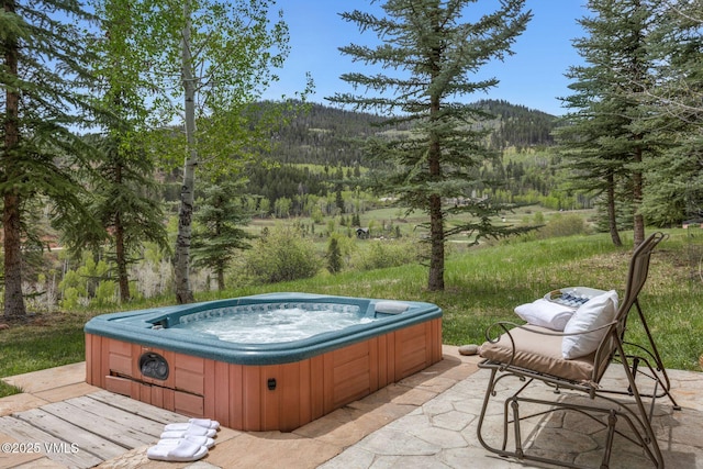124 Grey Hawk Ln, Edwards, CO 81632 - view of patio / terrace featuring a hot tub, a view of trees, and a mountain view