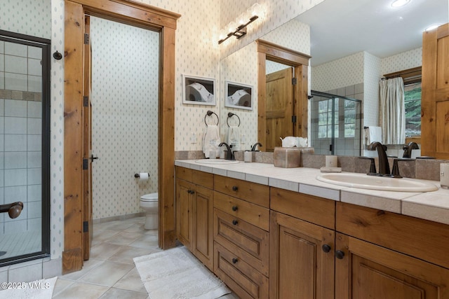 124 Grey Hawk Ln, Edwards, CO 81632 - bathroom with wallpapered walls, a shower stall, tile patterned floors, toilet, and double vanity