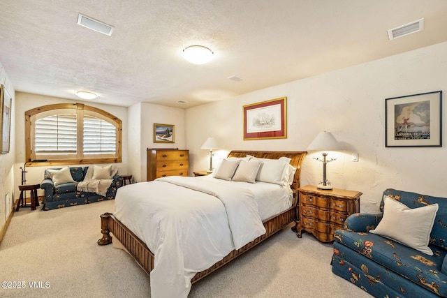 bedroom with light carpet and a textured ceiling