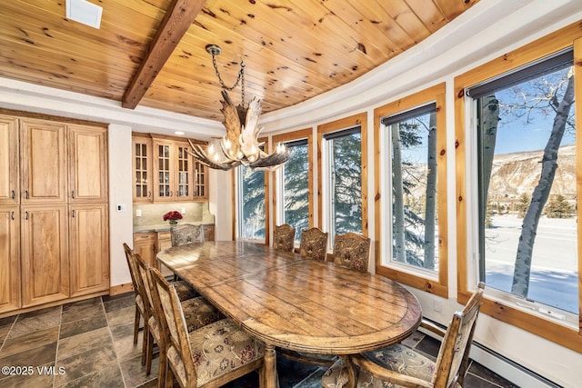 dining area featuring wood ceiling, beam ceiling, a mountain view, and an inviting chandelier