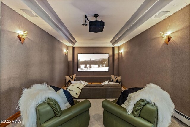 home theater room with a raised ceiling and a baseboard heating unit