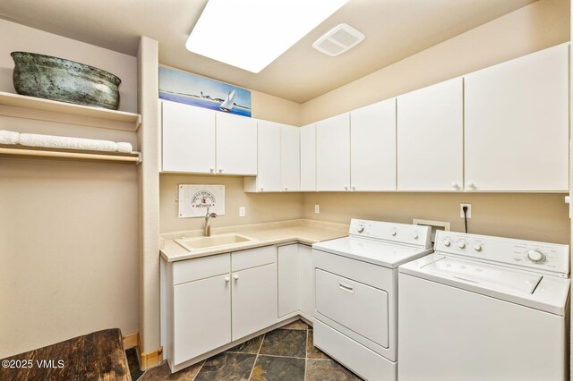 clothes washing area with cabinets, separate washer and dryer, and sink